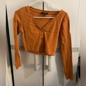 Orange colored long sleeve crop top